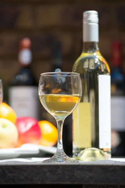 Catering service with white wine glass, fruits and wine bottle on bartender background