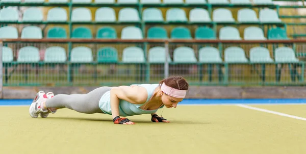 Young athletic woman doing core exercise outdoors