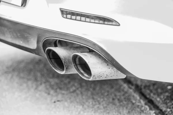 Double exhaust pipes of a modern sports car, black and white