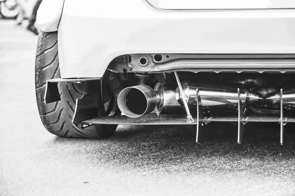 Double exhaust pipes of a modern sports car, black and white