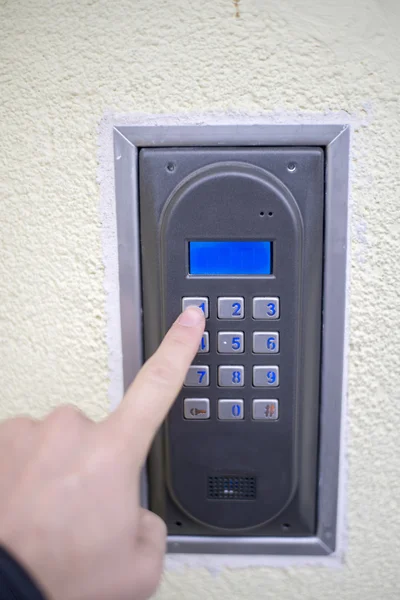 Human finger pushing button of house intercom