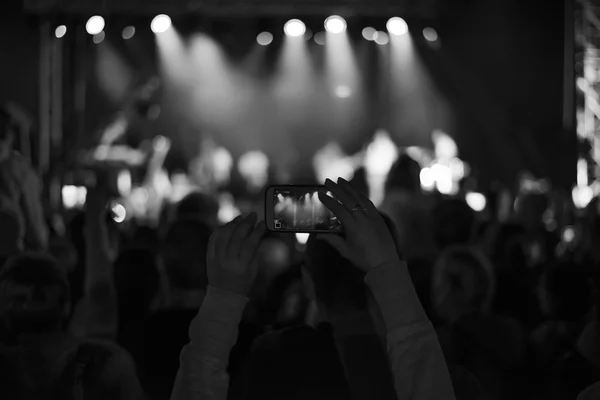 Supporters recording at concert, black and white, noise