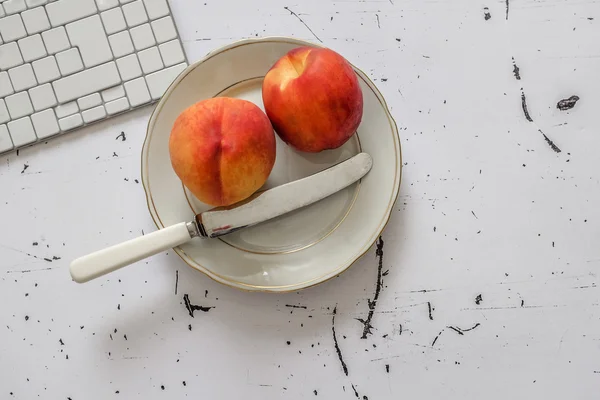 Fresh fruit in white plate on office table, top view