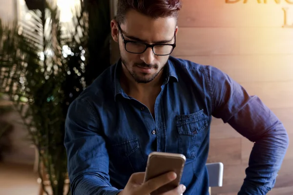 Elegant man with eyeglasses using smartphone