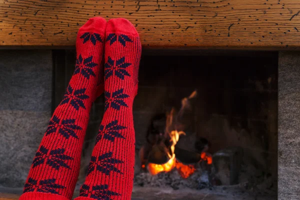 Feet in wool socks warming by cozy fire