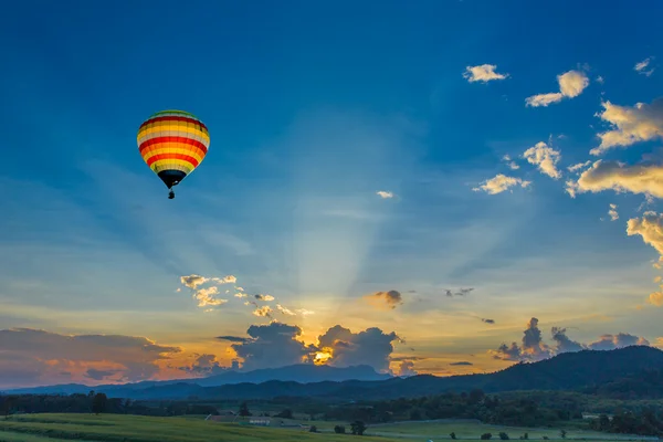 Hot air balloon over the fields at sunset