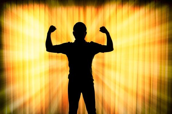 Silhouette man show his muscle with light ray effect