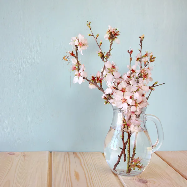 Spring bouquet of flowers on the wooden table with mint background. vintage filtered image