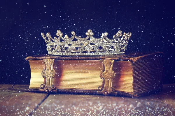 Decorative crown on old book. vintage filtered. selective focus