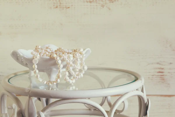 White pearls necklace on vintage table. selective focus