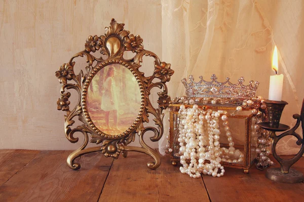 Vintage frame with old photo, pearls on wooden table