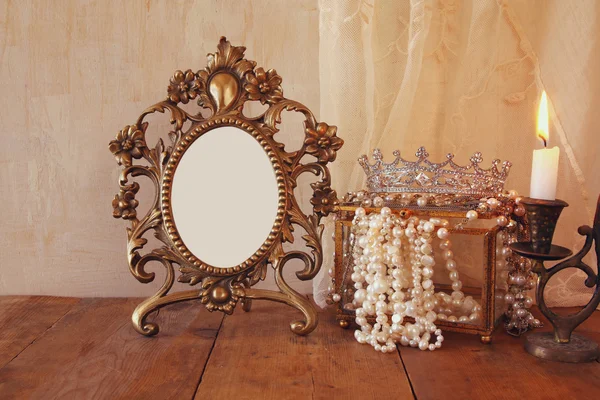 Blank vintage frame, pearls on wooden table