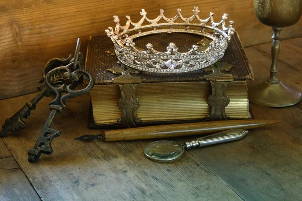 Low key image of diamond queen crown on old book