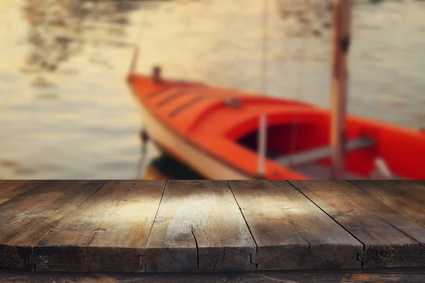 Image of wooden table in front of boat at the port