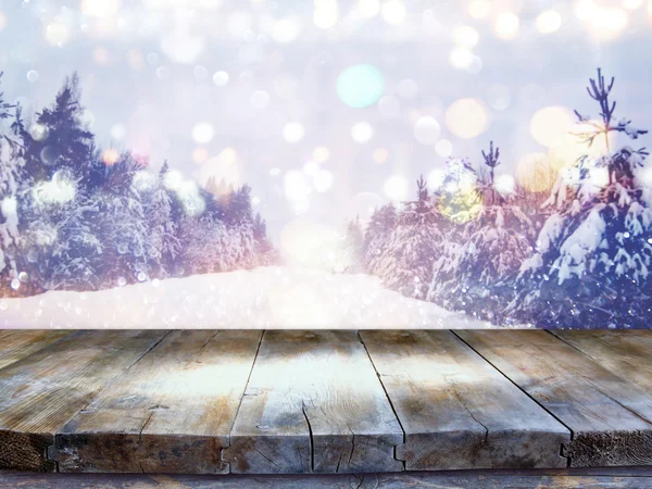 Empty wooden table in front of dreamy winter landscape