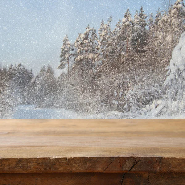 Empty wooden table in front of dreamy winter landscape