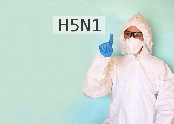 Lab scientist in safety suit drawing word H5N1