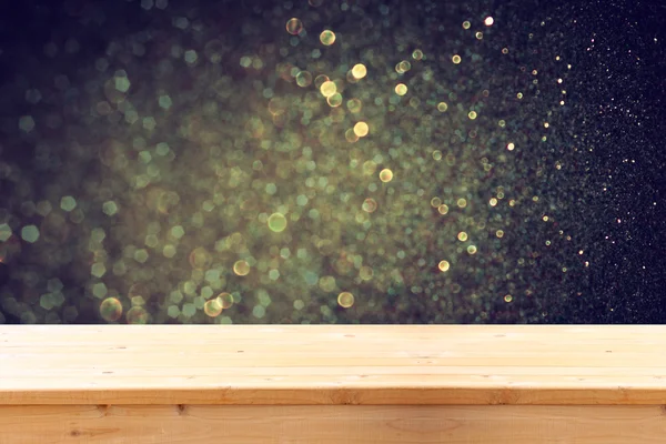 Rustic wood table in front of glitter gold bright bokeh lights