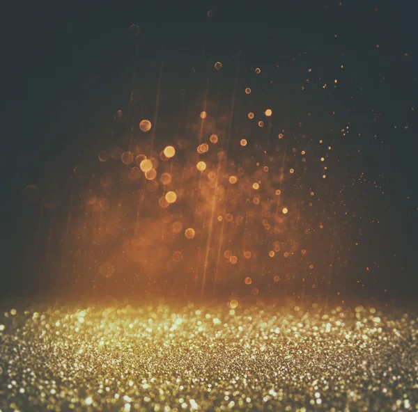 Glitter vintage lights background. light gold and black. defocused.