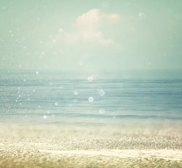 Background of blurred beach and sea waves with bokeh lights, vintage filter.