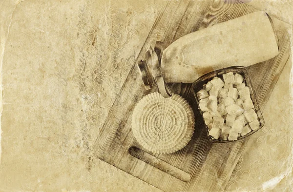 Image of greek cheese and bulgarian cheese on wooden table over wooden textured background. Symbols of jewish holiday - Shavuot. Black and white style photo.