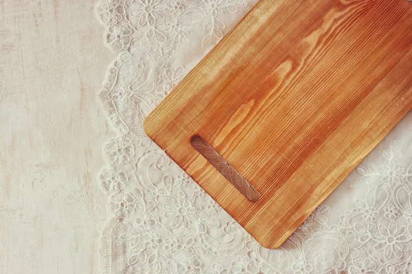 Top view of Cutting board on wooden table over vintage lace table cloth and wooden table. room for text