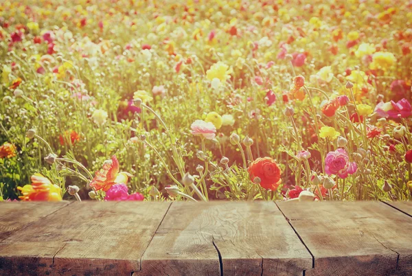 Wood board table in front of summer landscape with double exposure of flower field bloom