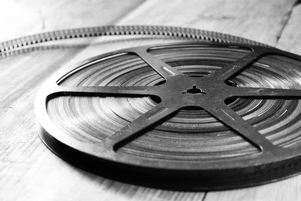 Top view image of old 8 mm movie reel over wooden background