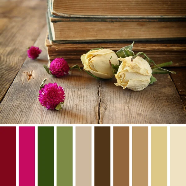 Selective focus image of dry rose and old vintage books on wooden table. vintage filter with palette color swatches