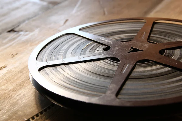 Image of old 8 mm movie reel over wooden background. retro style image.