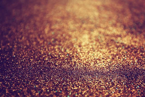 Glitter vintage lights background. dark gold and black. defocused.