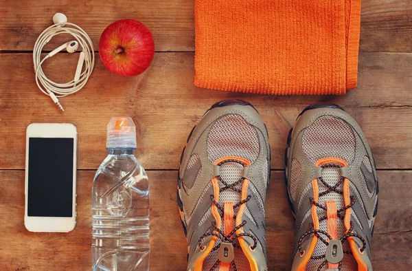 Fitness concept with sport footwear over wooden background.. top view image.