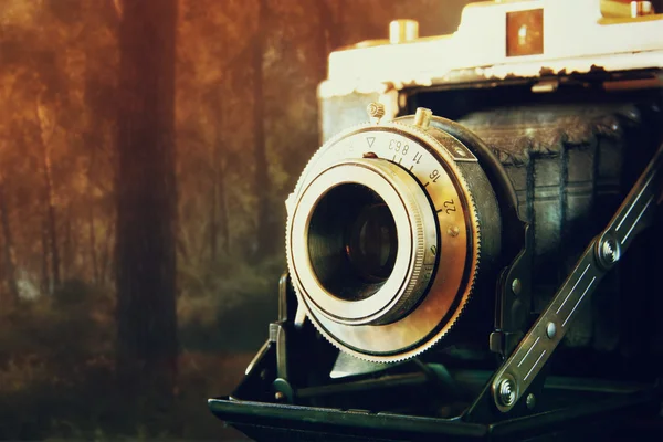 Double exposure and abstract photo of old vintage camera lens over wooden table. selective focus