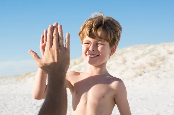 Boy giving high five to father