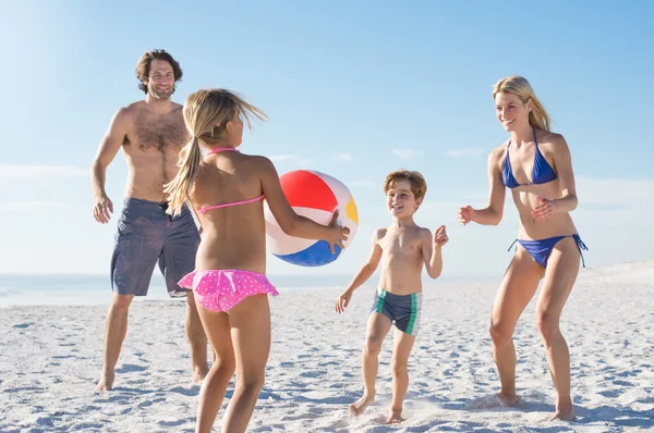Family playing with ball at beach
