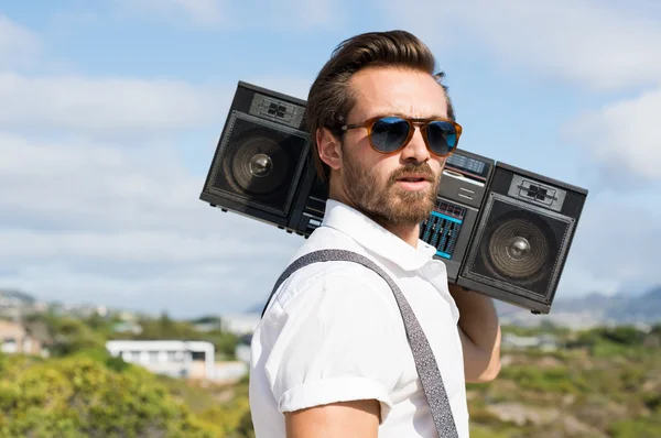 Hipster guy with vintage stereo on shoulder