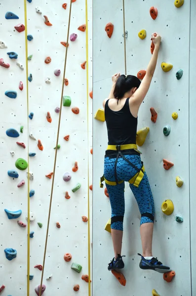 Rave teenage with harness climbing vertical wall