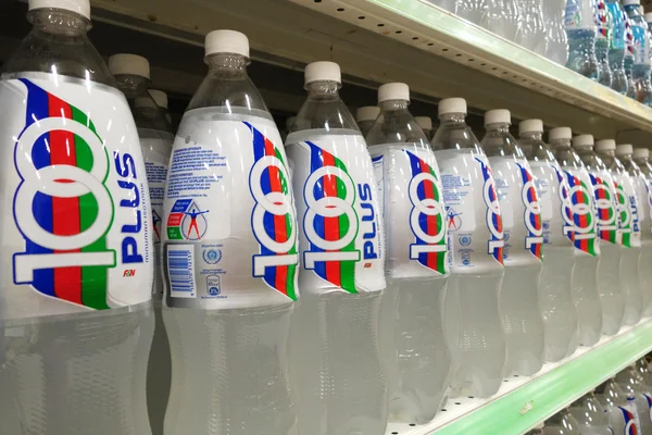 Bottles of 100Plus soft drink are displayed in market