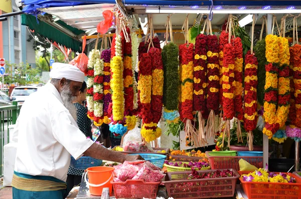 Temple florists prepare flowers and garlands for sale