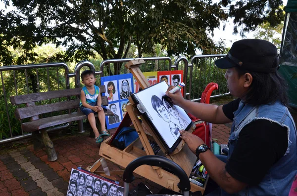 Local artist draws a quick sketch of children on top of Penang H
