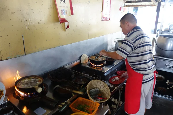 Chef prepares a stew of pork and herbal soup, ba kut teh in Tanj