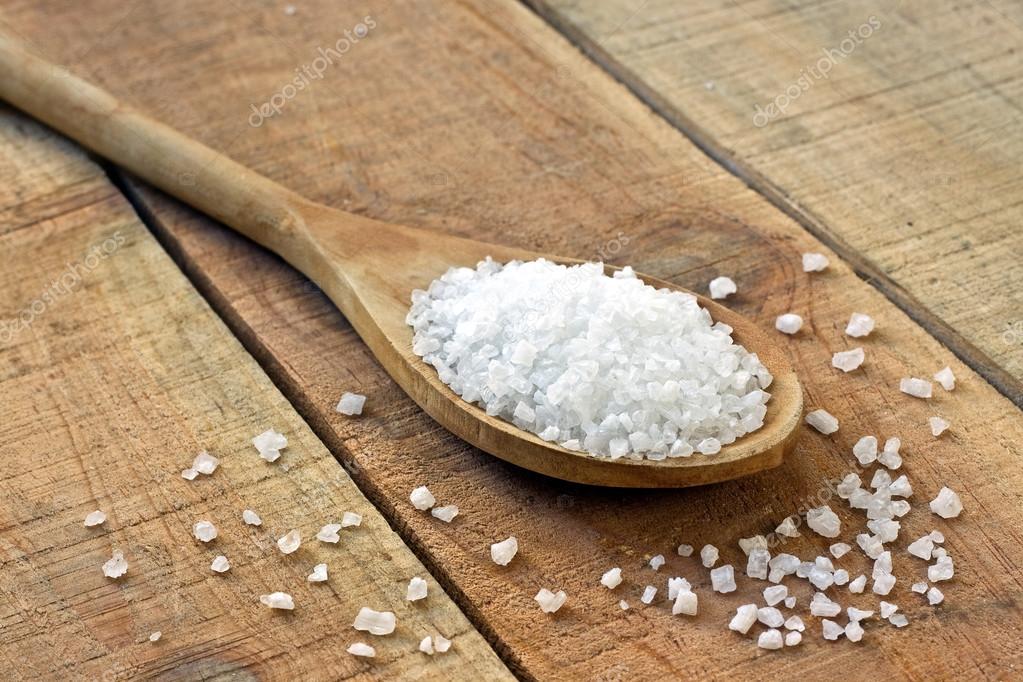 La sal en una cuchara sobre una mesa de madera — Foto de Stock