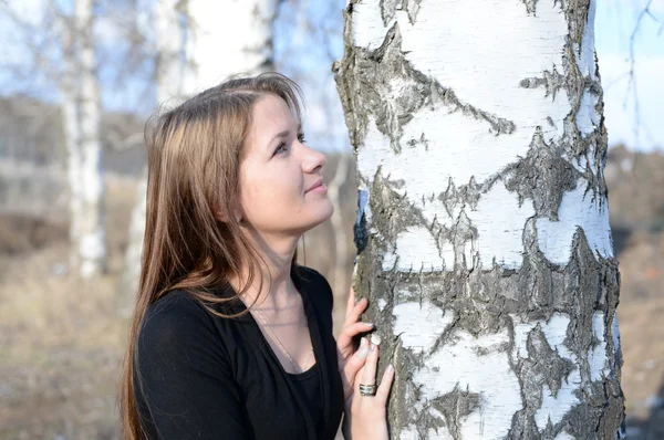 Long-haired girl in a Russian birch forest, close-up