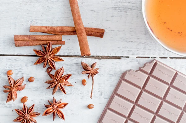 Cinnamon stick, star anise, bar of chocolate and cup of tea