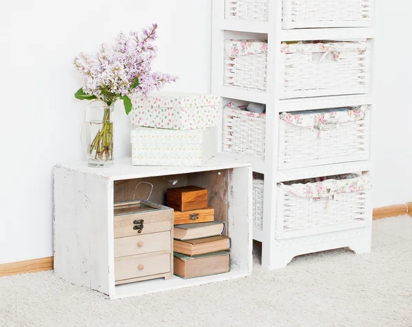 Nightstand with flowers, storage boxes and books