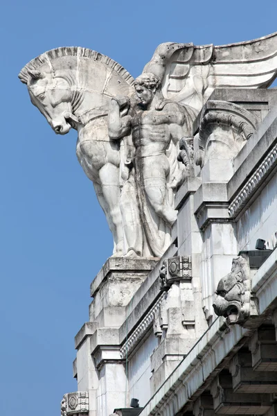 Statue of a man holding a winged horse on the Milan\'s main railway station