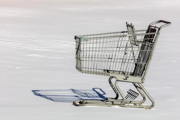 Shopping cart on the snow covered parking lot