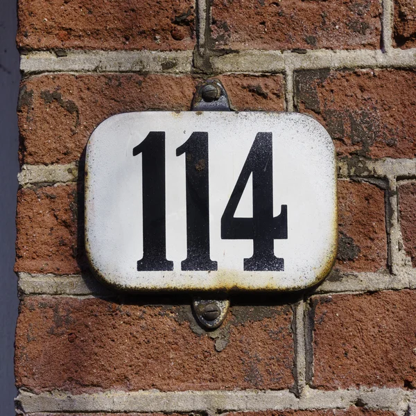 Number 114 - Enameled house number one hundred and fourteen.