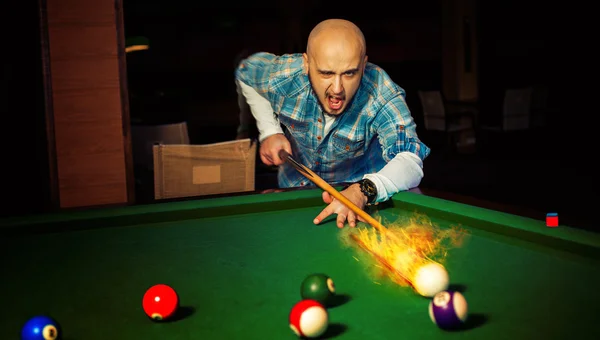 Horizontal photo angry man hits fireball at pool billiard