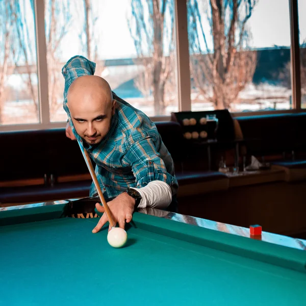 Square Photo Man preparing to hit the cue ball on a pool billiar